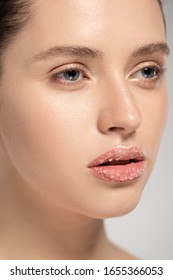 Beautiful Girl With Coconut Scrub On Lips, Isolated On Grey