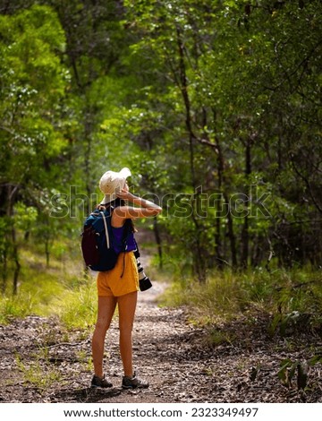 Beautiful girl in colorful clothes andmires the nature walking in Brisbane Koala Bushlands Park, Queensland, Australia; 