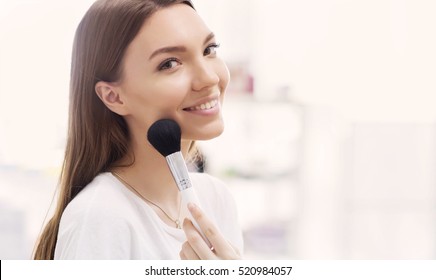 Beautiful girl with cosmetic powder brush for make up. Makeup. Make-up applying  for perfect skin. - Shutterstock ID 520984057