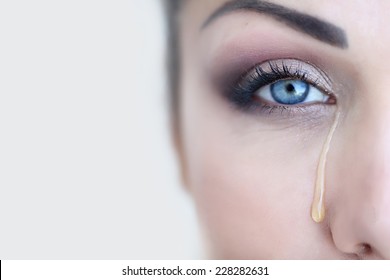 Beautiful girl crying. Tears. Female eye with a tear. Macro eye.