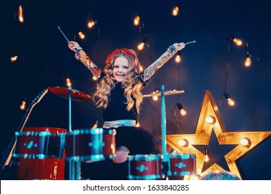 Beautiful Girl With Curly Hair Playing The Drums On A Black Illuminated Background