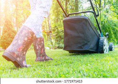 Beautiful Girl Cuts The Lawn. Mowing Lawns. Beautiful Woman Lawn Mower On Green Grass. Mower Grass Equipment. Mowing Gardener Care Work Tool. Close Up View. Lawn Mowing