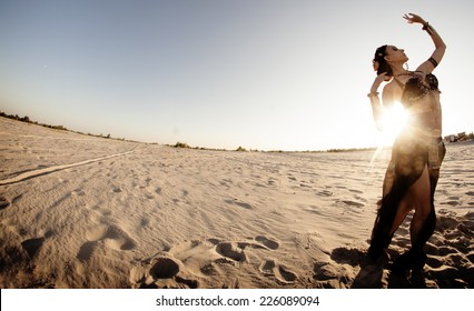 Beautiful girl dancing ethnic dances in desert