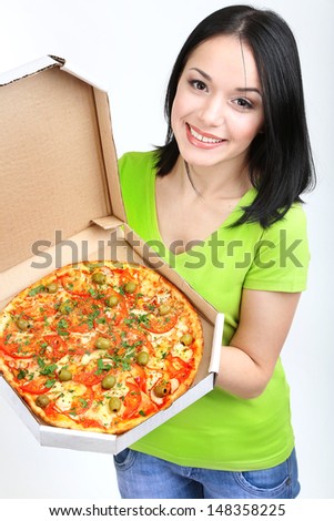 Beautiful girl with delicious pizza in pizza box isolated on white