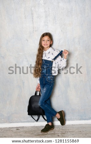 Beautiful girl in denim clothes with bag. Schoolgirl. 