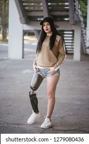 A beautiful girl is disabled with a prosthesis on one leg.