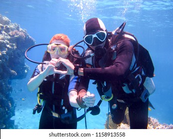 A Beautiful Girl Diver Shows Hands Gesture Signal All Well With A Partner Instructor For Safety Floats Under The Water In The Red Sea With Coral Reefs Egypt, Sharm El-Sheikh, 05/15/2018.