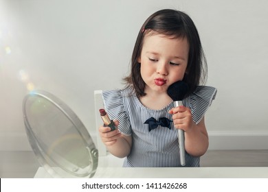 Beautiful Girl Does Makeup. Little Girl Plays With Her Mother's Makeup. Funny Makeup Baby. A Woman Of Fashion Paints Her Eyes And Lips. A Girl In A Blue Blouse At The Mirror. 