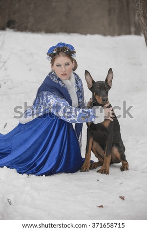 Beautiful girl with a dog in winter clothes