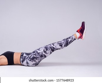 Beautiful Girl Doing Exercise Abdominal Crunches, Pumping Press On White Background. Cropped Body No Face