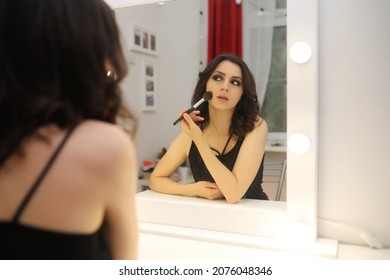 Beautiful Girl Doing Makeup In Front Of A Mirror
