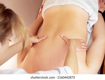 A Beautiful Girl Is Doing A Massage. The Authentic Image Of Luxury Spa Treatment. Warm Colors, Charming Light.