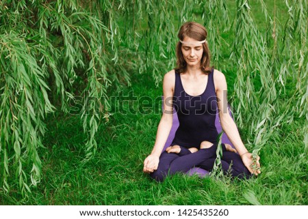 beautiful girl doing yoga on nature in the park