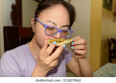 Beautiful girl with down syndrome, trisomy 21 eating a delicious