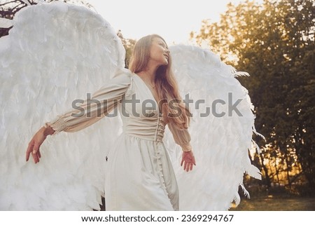 Beautiful girl dressed as an angel in the evening garden