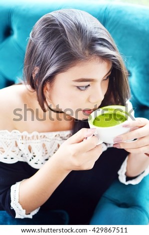 Beautiful Girl Drinking Tea or Coffee in vintage color toned style
