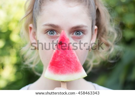 Beautiful girl eating fresh watermelon on green background