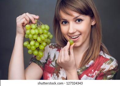 the beautiful girl is eating the green grapes
