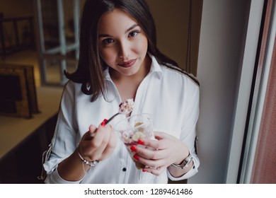 Beautiful Girl Eating Oatmeal With Greek Yogurt And Fruit In The Office