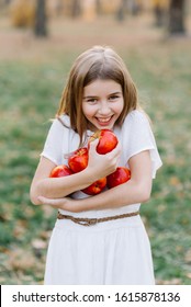 Beautiful Girl Eating Organic Apple In The Orchard. Harvest Concept. Garden, Toddler Eating Fruits At Fall Harvest. Apple Pie