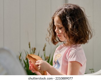 Beautiful Girl Eating Pita In The Backyard