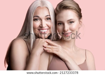 Beautiful girl with elderly mum hugging. Smiling mature gray-haired mother and young adult daughter cuddling. Happy family enjoying tender moment, female generations, 