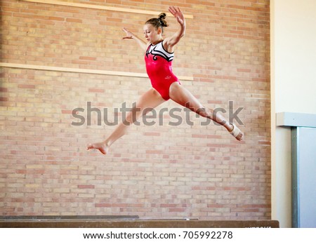 beautiful girl is engaged in sports gymnastics on a log