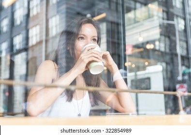 beautiful girl enjoying an hot coffee inside a shop in New york