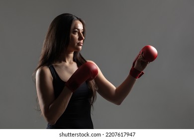 Beautiful Girl Exercising Karate Punch Against Gray Background