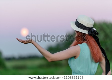 Beautiful girl in the field against the sky with the moon-lifestyle concepts