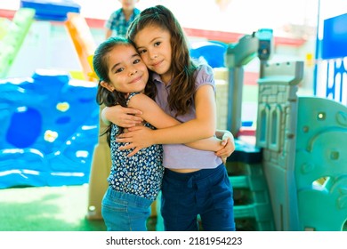 Beautiful Girl Friends Hugging And Smiling While Playing In The Playground During Kindergarten Recess