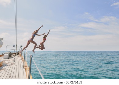 Beautiful Girl Friends Jumping Into Blue Sea From Luxury Wooden Sailboat Fun Happy Lifestyle Ocean Vacation Travel 