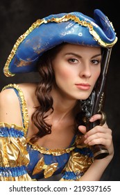 Beautiful girl with a gun in a suit Musketeers.