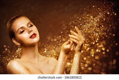 Beautiful Girl Hands And Face Skin Care Treatment. Golden Glitter Luxury Makeup. Closed Eyes. Sparkling Gold Dust Background