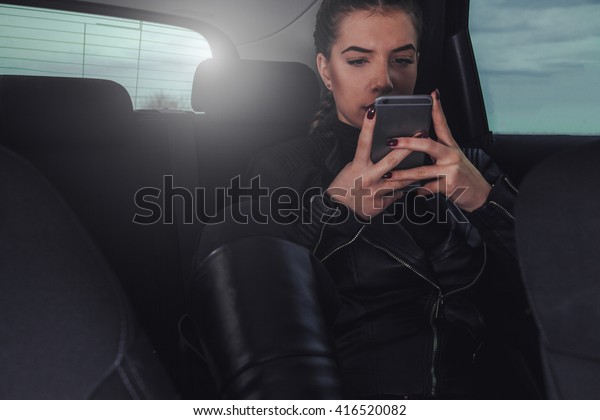 Beautiful girl in\
her car with her mobile\
phone.
