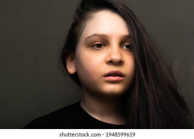 A Beautiful Girl With Her Hair Pulled Back On Her Side Looks Away. A Pensive, Sad Face. Dyed Strands Of Hair In Purple. 