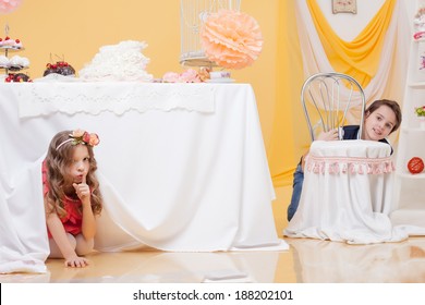 Beautiful Girl Hiding Under Table From Her Brother