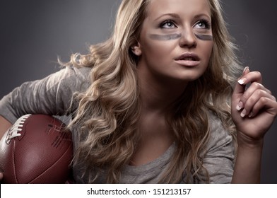 beautiful girl holding a ball for american football