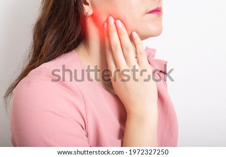 Beautiful girl holding her hand on the lower jaw of the tooth, which has an inflamed tooth nerve, dental abscess. Close-up Stockfoto © 