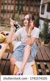 A Beautiful Girl Is Holding Pepsi Bottle By The Trailer.