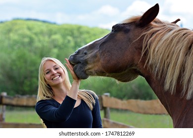 Beautiful girl with a horse on a meadow