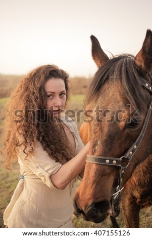 Beautiful girl with a horse outdoors in the countryside. 