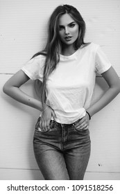 Beautiful girl in jeans and a T-shirt on the street. Black and white photo