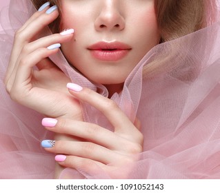Beautiful girl with light make-up and gentle manicure in pink clothes. Beauty face. Design nails. Photo taken in studio on pink background