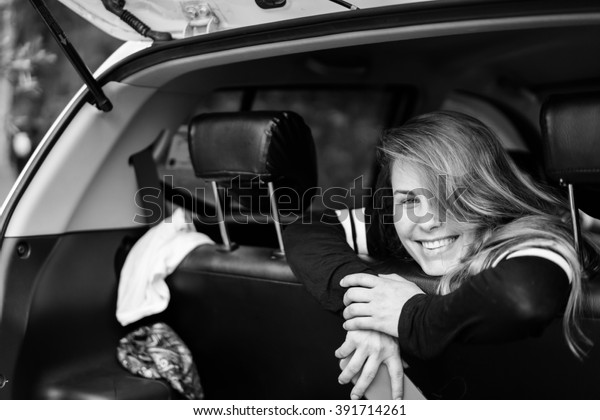 beautiful girl , like a cheerleader . Attractive\
girl sitting in a car and smiling . pretty girl traveling in a car\
with friends.
