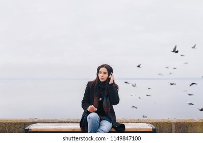 Beautiful Girl Listening To Music On Headphones On A Nature Background. Enjoy Your Favorite Song. Copy Space.