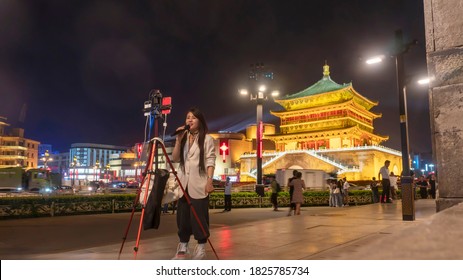 The beautiful girl "living video streaming" under the bell tower. Xian City, Shaanxi Province, China. September 11th, 2020.