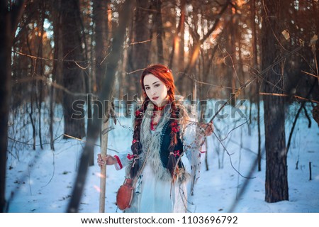 Beautiful girl with long braids in a winter forest. A witch from a fairy tale. fantasy Photo