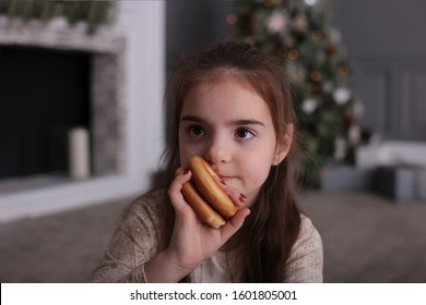 Beautiful girl with long dark hair is fooling around with cookies on New Year's bokeh lights at a decorated Christmas tree - Shutterstock ID 1601805001