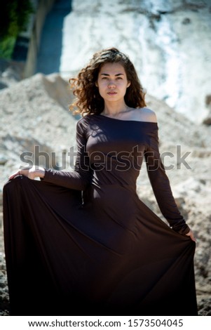 beautiful girl in long dress on sand quarry